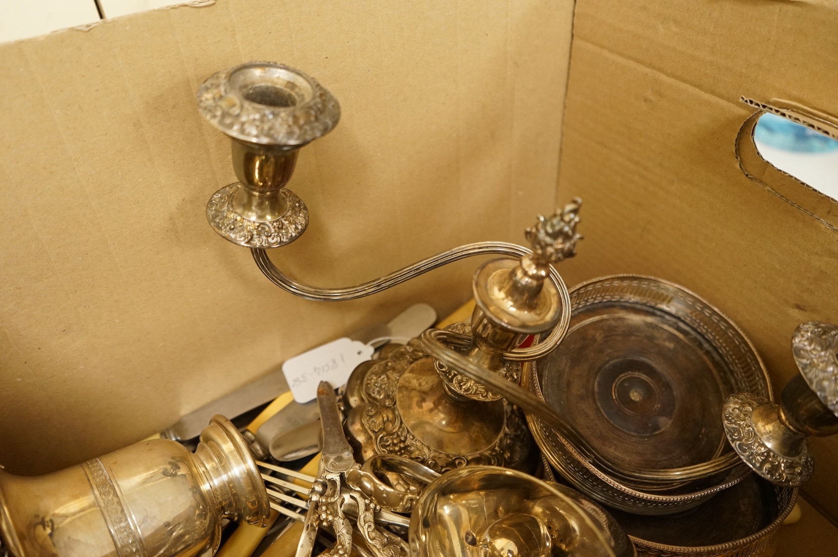 A group of sundry plated items including dwarf candelabra, a pair of wine coasters, a pair of grape shears, etc., and a quantity of assorted ivorine handled table and dessert knives.